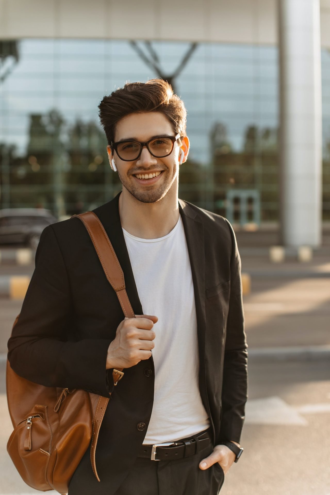 happy businessman in eyeglasses looks into camera and smiles sincerely brunette guy in black jacke